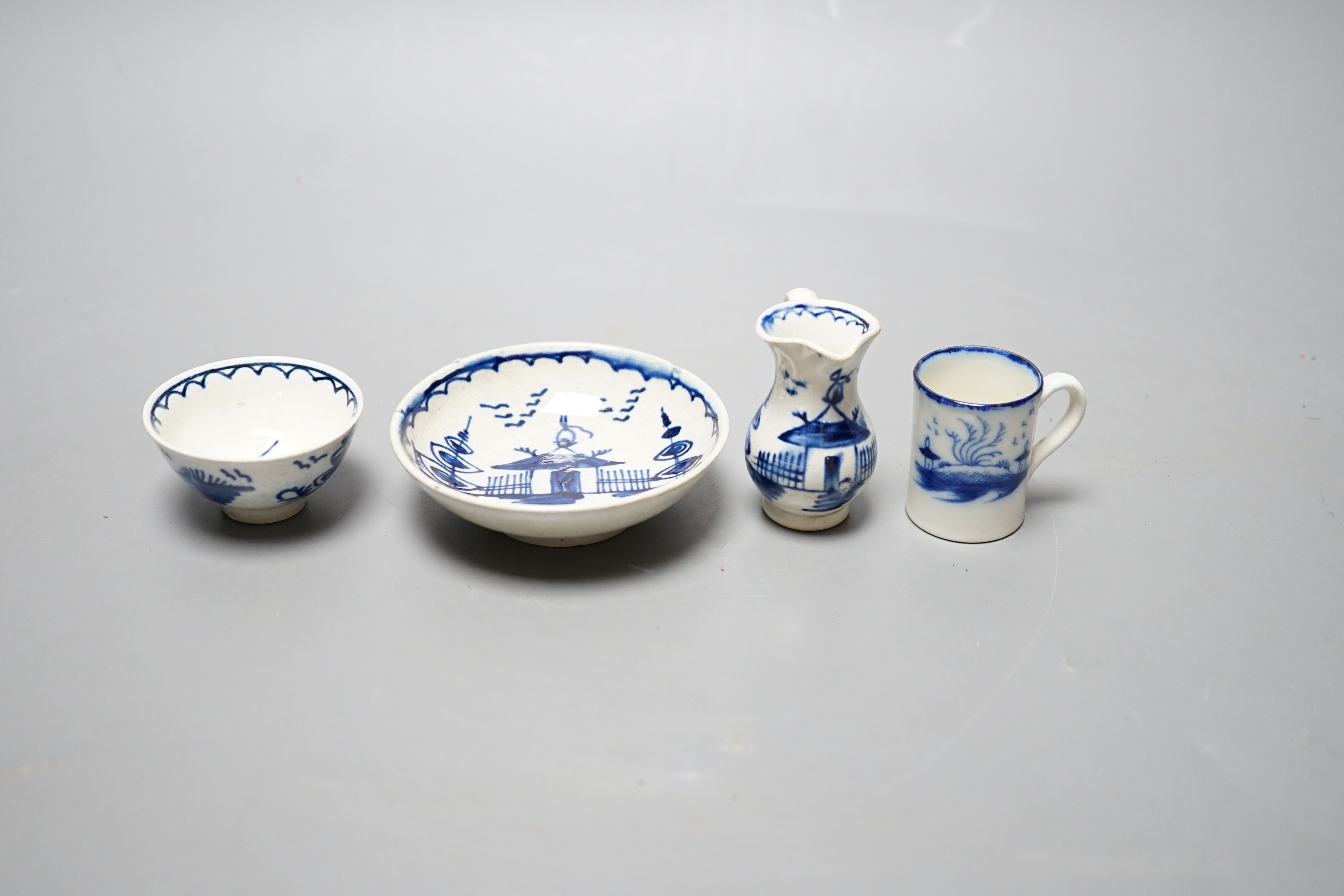 A late 18th century pearlware blue and white miniature jug, 5cm, and tea bowl and an English porcelain miniature mug, late 18th century